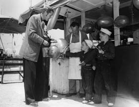 Dan Duryea Buys Balloons and Popsicles for His Sons, Dick and Peter. (1947)